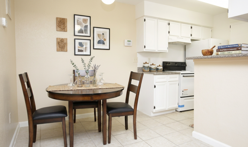 Dining area with round wood table at Falls of Kirkwood Houston apartments